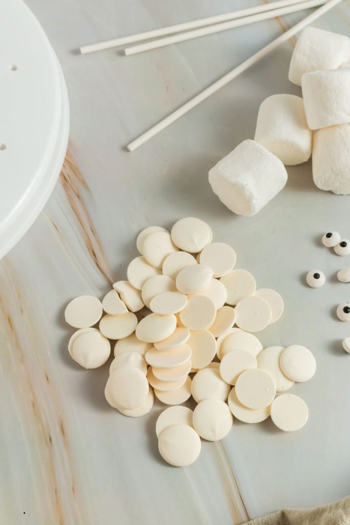 top views of white candy circles, cany eyeballs, lollipop sticks and marshmallows